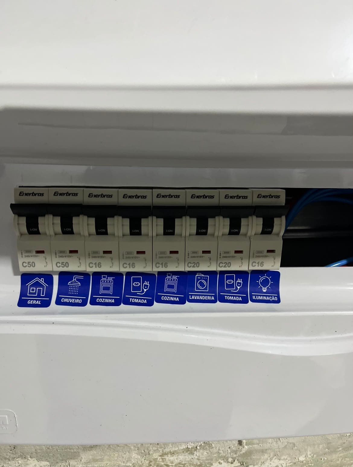 Quadro de distribuição residencial com disjuntores identificados por adesivos de circuito